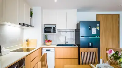 a kitchen with a blue refrigerator and a table at Beachside Residence 4 floor, Seaside, 250m to the beach in Bang Tao Beach