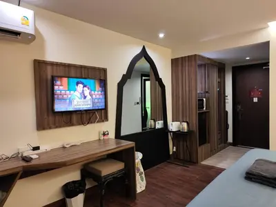 a hotel room with a television and a bedroom at 8 Floor - Mountain view Studio room at TBHR near Kata beach in Kata Beach