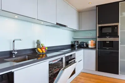 a kitchen with white cabinets and black appliances at Ocean View 3BR Apartment with Rooftop Terrace, Sapphire Bay 8-19 Residence in Patong Beach