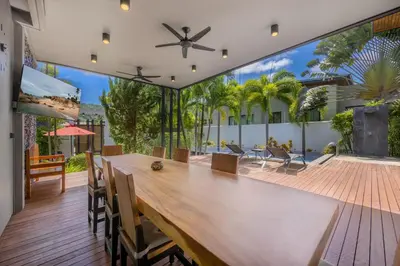 a dining room with a large wooden table in a house at Villa Fam with Private Pool Near Nai Harn Beach in Rawai Beach
