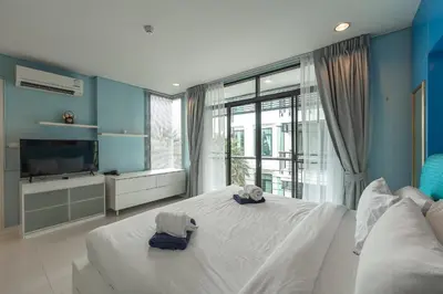 a bedroom with a large white bed with towels on it at C205 4BR Pool, Mountain Views & Prime Location in Kamala Beach