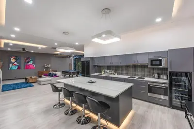 a large kitchen with a large island with bar stools at V204 Tropical Score 3BR with Pool, Tub & Snooker in Rawai Beach