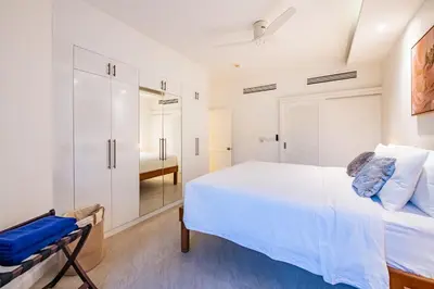 a white bedroom with a large bed and a walk in closet at JSD Prime Property-Cherngtalay in Laguna Phuket