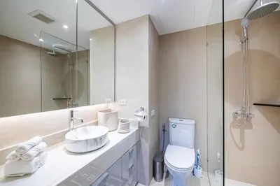 a bathroom with a toilet and a sink and a mirror at JSD Prime Property-Cherngtalay in Laguna Phuket