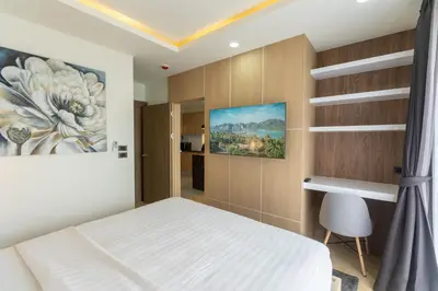 a bedroom with a bed and a painting on the wall at Calipso Garden in Rawai Beach