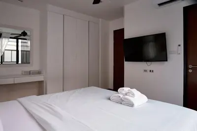 a bedroom with a white bed with towels on it at Spacious 3 bedroom townhouse in Laguna in Laguna Phuket
