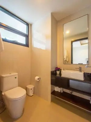 a bathroom with a toilet and a sink and a mirror at Spacious 3 bedroom townhouse in Laguna in Laguna Phuket