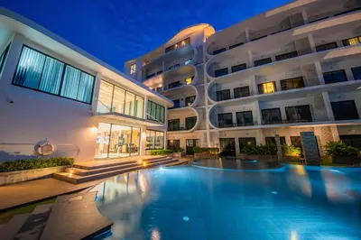 a large apartment building with a swimming pool at night at \u4e5d\u96c5\u96c6 The Nine Refined Retreats in Rawai Beach