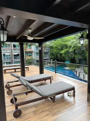 a deck with two chaise lounges and a pool at The title Naiyang - Beach Condos in Nai Yang Beach