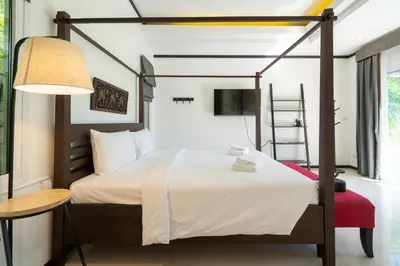 a bedroom with a canopy bed with a table and a lamp at Villa Prima - 3 Bedroom Private Pool Villa in Rawai Beach