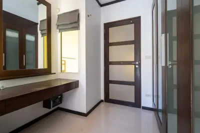 a bathroom with a mirror and a wooden door at Villa Prima - 3 Bedroom Private Pool Villa in Rawai Beach
