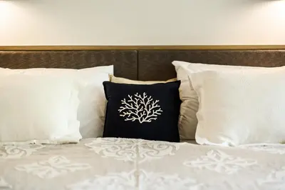 a bed with white pillows and a black and white pillow at JSD Prime Property-Kamala Beach in Surin Beach