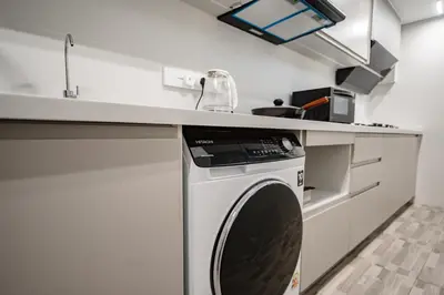 a kitchen with a washing machine under a counter at DreamHouse in Ban Bang Khu