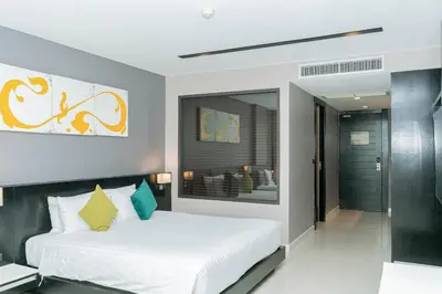 a bedroom with a large white bed in a room at Beachfront and Deluxe Pool Access Patong Phuket in Patong Beach