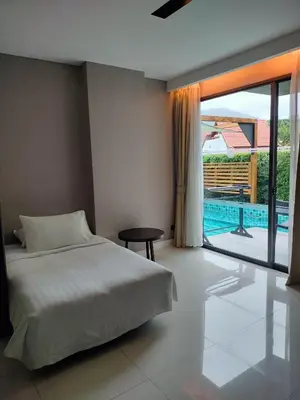 a bedroom with a bed and a view of a pool at Beachfront Family Pool 1 BR 1 Living Patong Phuket in Patong Beach