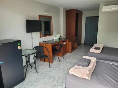 a hotel room with a bed and a desk and a table at Sunflower Guesthouse in Karon Beach