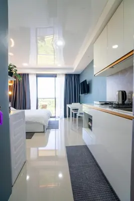 a kitchen and a bedroom with a bed in a room at White Room in Ban Mai Salae