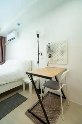 a desk and a chair in a room with a bed at White Room in Ban Mai Salae