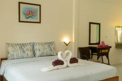 two swans made out of towels sitting on a bed at The Golden Beach Resort Naiyang in Nai Yang Beach