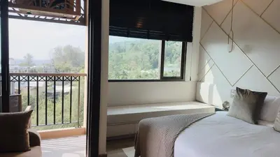 a bedroom with a bed and a large window at Praud Karon 605 in Karon Beach