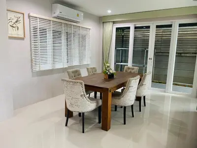 a dining room with a wooden table and chairs at PhuketMadameBuppa Siwali Village in Ban Phlu Yai
