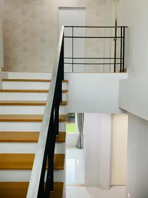 a staircase in a house with white walls at PhuketMadameBuppa Siwali Village in Ban Phlu Yai