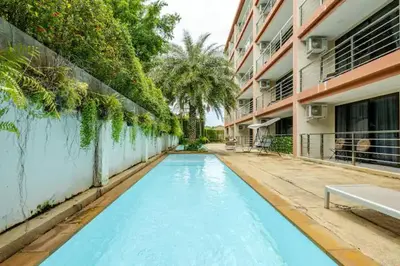a swimming pool in front of a building at Room 402 Rawai Beach Condo in Nai Harn Beach