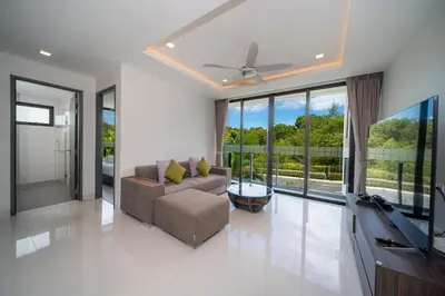 a living room with a couch and a television at Modern Minimalist 6 Bedroom Light Luxury Villa Private Pool Golf Course Laguna Park in Bang Tao Beach
