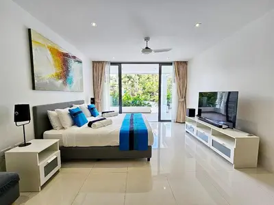 a bedroom with a bed and a flat screen tv at Stylish 2-Bedroom Apartment with Pool Access in Surin Beach