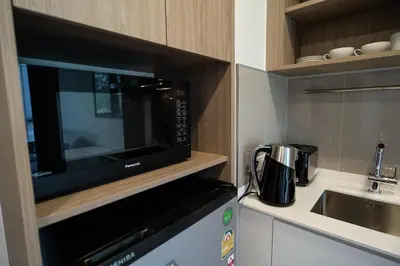 a kitchen with a microwave and a sink at Laguna Skypark spacious 1 bedroom apart Bangtao in Laguna Phuket