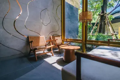 two chairs and a table in a room with windows at Cozy 1 BR beachfront apartment in Bang Tao Beach