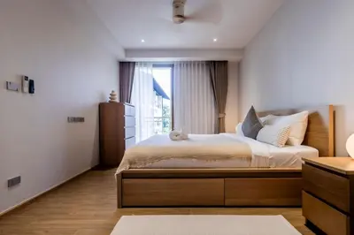 a bedroom with a large bed and a window at Cozy 1 BR beachfront apartment in Bang Tao Beach