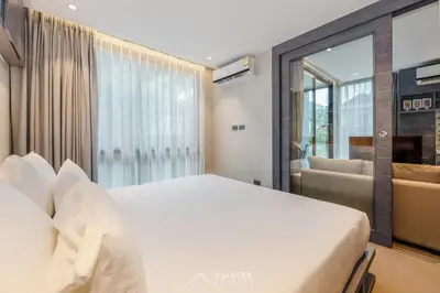 a bedroom with a white bed and a large window at CityGate Kamala 1BR 3 min Beach in Kamala Beach