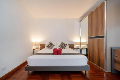 a bedroom with a bed with two red pillows at Beautiful 2BR Lakeview Apartment in Laguna in Laguna Phuket