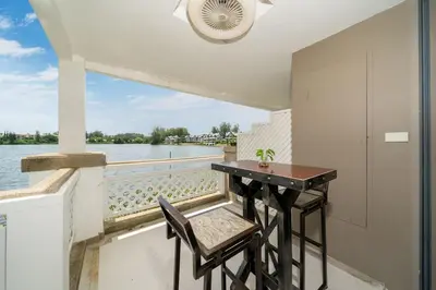 a balcony with a table and chairs and a view of the water at Beautiful 2BR Lakeview Apartment in Laguna in Laguna Phuket