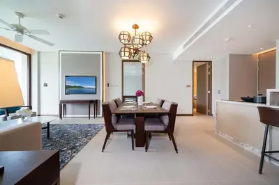 a living room with a table and chairs and a kitchen at Angsana Oceanview Residence Luxurious 2BR Lakeview Apartment in Laguna Phuket