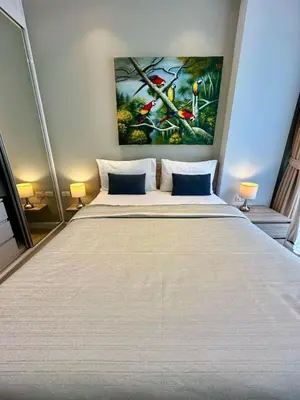 a bedroom with a large bed with a painting on the wall at Diamond Condominium 1 BR Bangtao beach in Bang Tao Beach