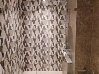 a bathroom with a shower with a tiled wall at Endless white 2BR apartment-300m to NaiYang Beach in Nai Yang Beach