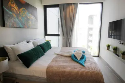 a bedroom with a bed with a stuffed animal on it at Cassia Lakeview 1BR Apartments, 10min to Beach in Laguna Phuket