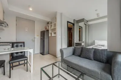 a living room with a couch and a table at C207 Rooftop Pool & King Bed, Walk to Surin Beach in Surin Beach