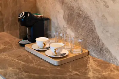 a tray with cups and glasses on a coffee maker at The Ozone Residences Bangtao in Phuket