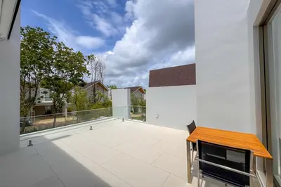 an empty balcony with a view of a house at New Tropical Modernity! 3BR Pool Villa LuxPride4 L21 near Laguna Phuket in Bang Tao Beach
