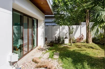 a house with a garden in front of it at Serene Contemporary Villa with a Swimming Pool in Ban Saiyuan (1)