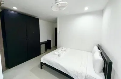 a bedroom with a white bed with shoes on it at Patong Easy Life 3 in Patong Beach