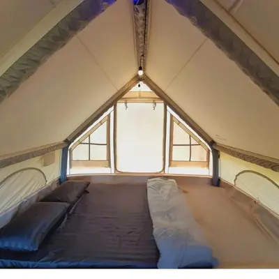 a bed in a tent with a window at Sea True Valley Phuket ซี ทรู วัลเลย์ ภูเก็ต in Ban Ao Makham