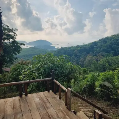 a wooden deck with a view of the mountains and forests at Sea True Valley Phuket ซี ทรู วัลเลย์ ภูเก็ต in Ban Ao Makham