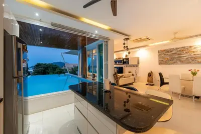 a kitchen and living room with a view of a pool at V210 Retreat 3BR Top of the Range, Sea View,Lift in Rawai Beach