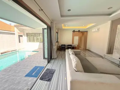 a living room with a couch and a swimming pool at Quiet Harbor in Ban Saiyuan (1)