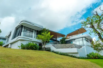 a white house on top of a hill at Zavaya Luxury Private Pool Villa Phuket in Layan Beach