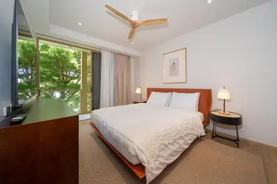 a bedroom with a bed and a large window at Laguna Beachside Apartment 300 meters to the Bangtao Beach in Bang Tao Beach